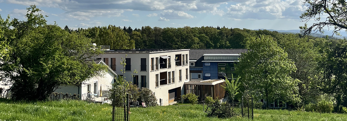 Blick über die Wiese auf das Pflegeheim St. Chrischona am Waldrand